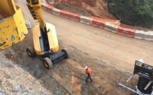construction worker are mining site, walking near an excavator