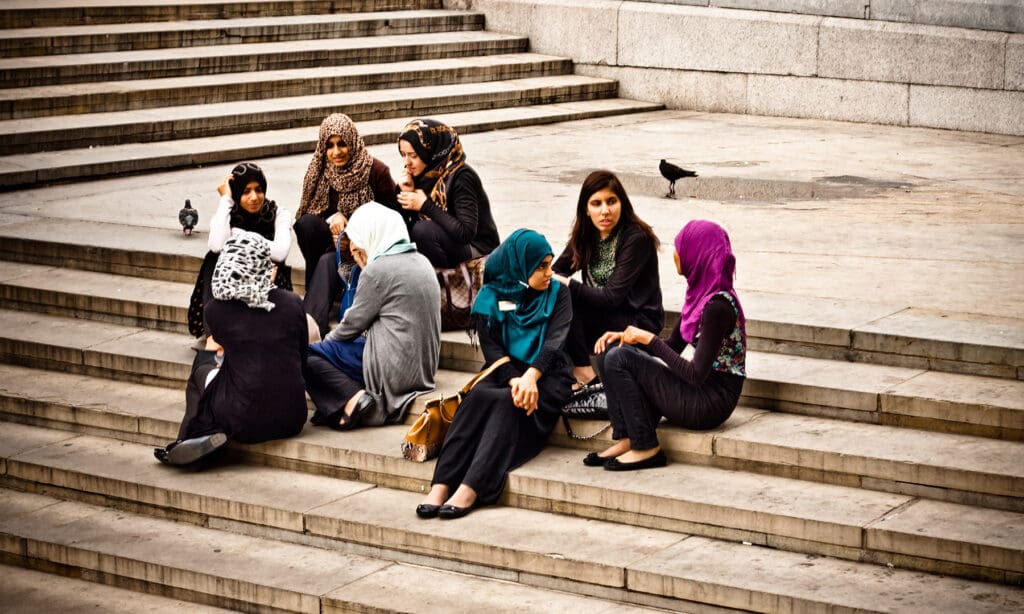 women sitting on stairs in a university setting