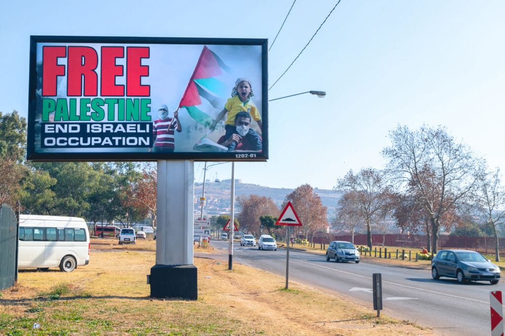 Billboard highlighting the movement to free Palestinian lands. Billboard is close up with a busy road to the right of the sign.