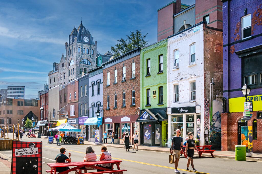 St. Johns, Newfoundland, Canada. Small groups of people walk down Water St. in St. Johns during the weekly street fair when the street is closed to traffic and businesses can better display their stores offerings.