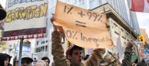 A protestor holding a placard stating the inequality of capitalism during the Occupy Toronto Movement on October 17, 2011 in Toronto, Canada. © arindambanerjee via Shutterstock