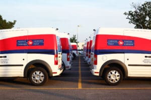 Toronto, Ontario, Canada - June 26, 2013: Close-up view of Canada Post fleet vehicles standing near the office in line (two rows) - side view. Image: iStock