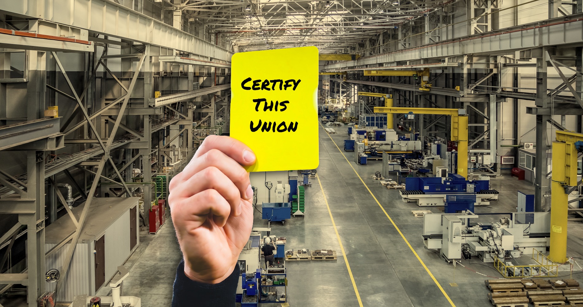 Factory in background with a hand holding a yellow card that says certify this unon