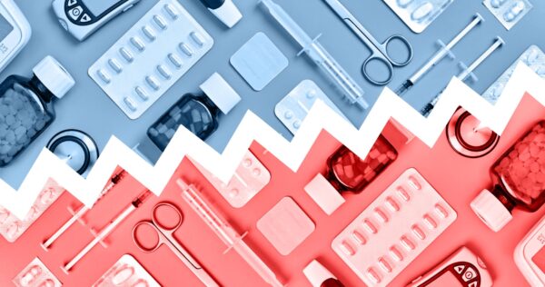 A variety of medical tools and medicine arranged on a plain background with a line drawn through it depicting the contrast between public and private health spending
