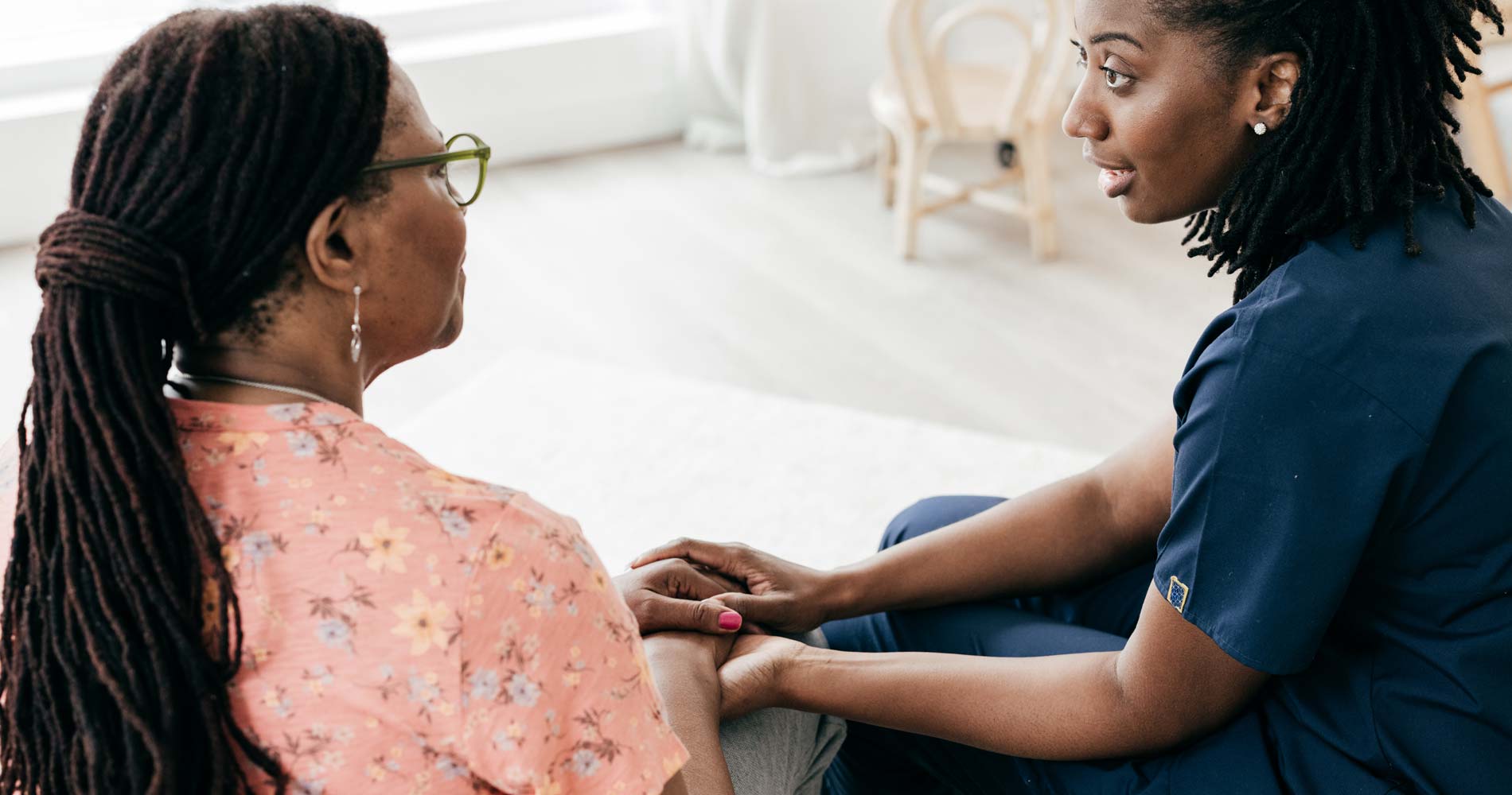 A woman talking with another woman who is working as her caregiver